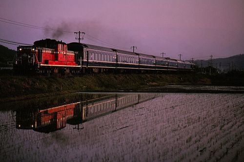 山陰本線の田植えの終わった水田風景を行く懐かしのDD51牽引の寝台特急「出雲」とローカル客車列車(淀江~大山口)