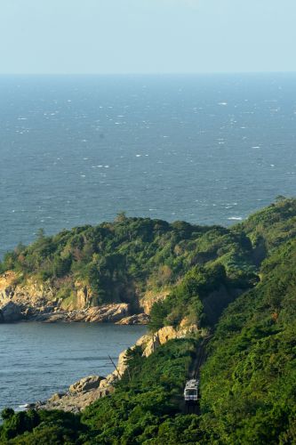 山陰本線のさざ波立つ海岸線を行くキハ120ローカル列車(岡見~鎌手)