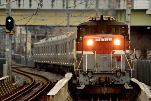 おおさか東線の城北公園駅を通過するDE10-1743号機牽引の甲種輸送南海8300系と201系電車(城北公園駅)