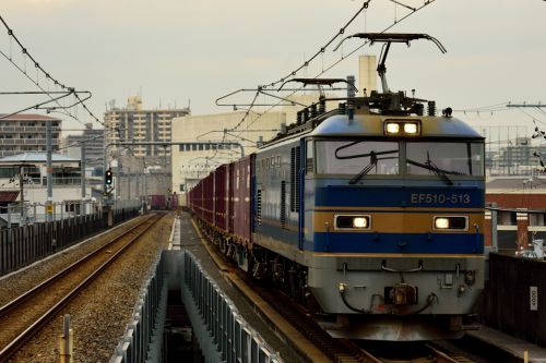 おおさか東線の高井田中央駅を通過する201系通勤電車とEF510牽引のコンテナ貨物(高井田中央駅)